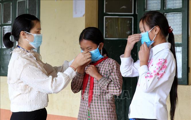 Giáo viên hướng dẫn học sinh đeo khẩu trang phòng dịch