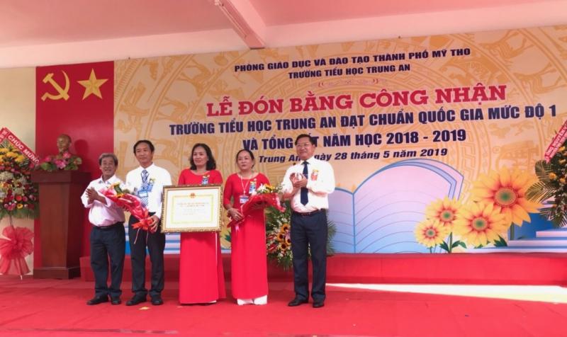 Bí thư Thành ủy TP. Mỹ Tho ông Đặng Thanh Liêm (bìa phải) và ông Trần Văn Dũng (Trưởng Phòng Giáo dục Mầm non -Tiểu học Sở Giáo dục – Đào tạo) trao bằng công nhận chuẩn Quốc gia mức 1 cho trường